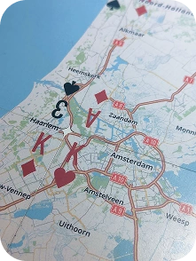 A close-up of adjoining map playing cards showing roads, towns and card suits